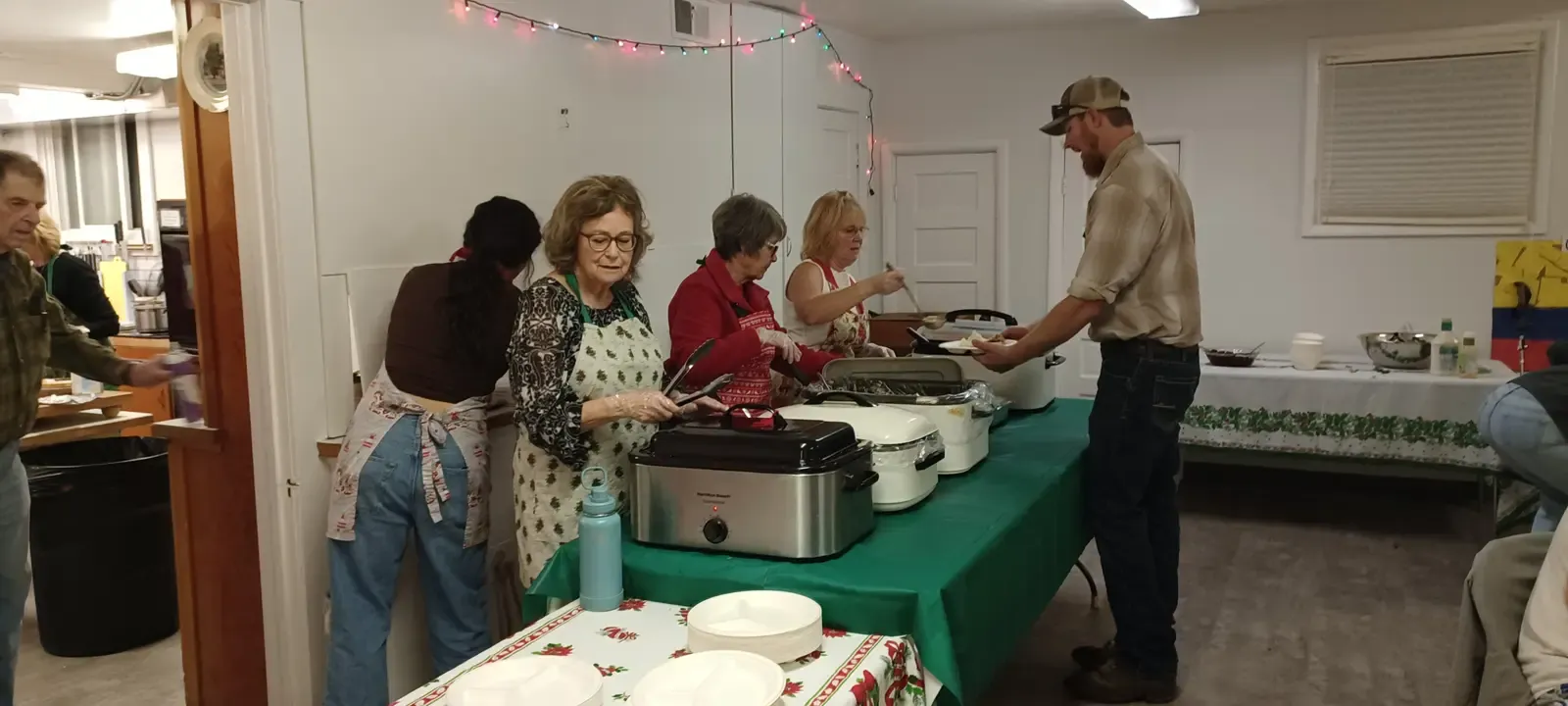 Church members serving a shared meal in the fellowship hall